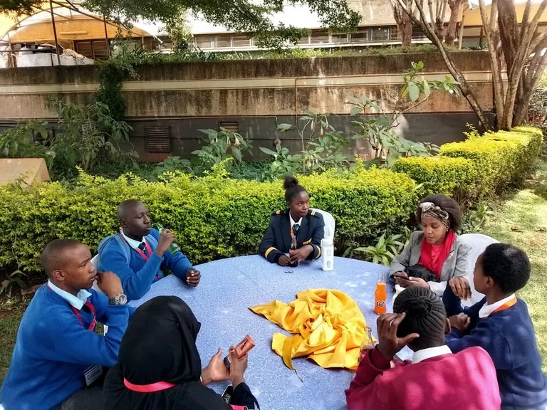 Young leaders sharing ideas around a table outdoors